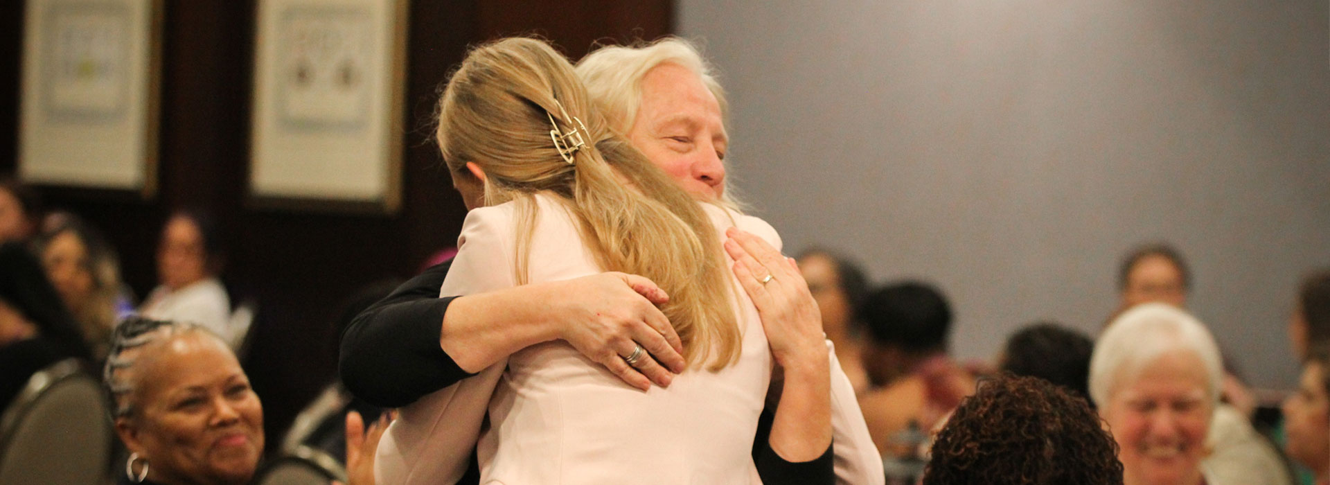women hugging at conference
